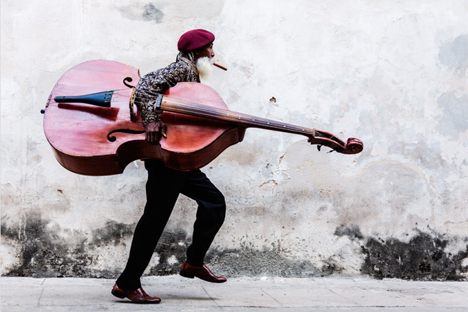 Cuban Man with Large Moustache Walking with Double Bass by Jeremy Woodhouse