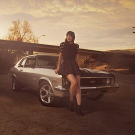 A woman in a dark dress leaning against a vintage car on a dirt road at sunset, illustrating how to find hidden exposures in Photoshop