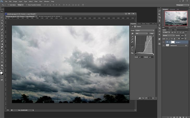 A stormy sky and treeline photograph open in Photoshop with a Curves adjustment panel on the right