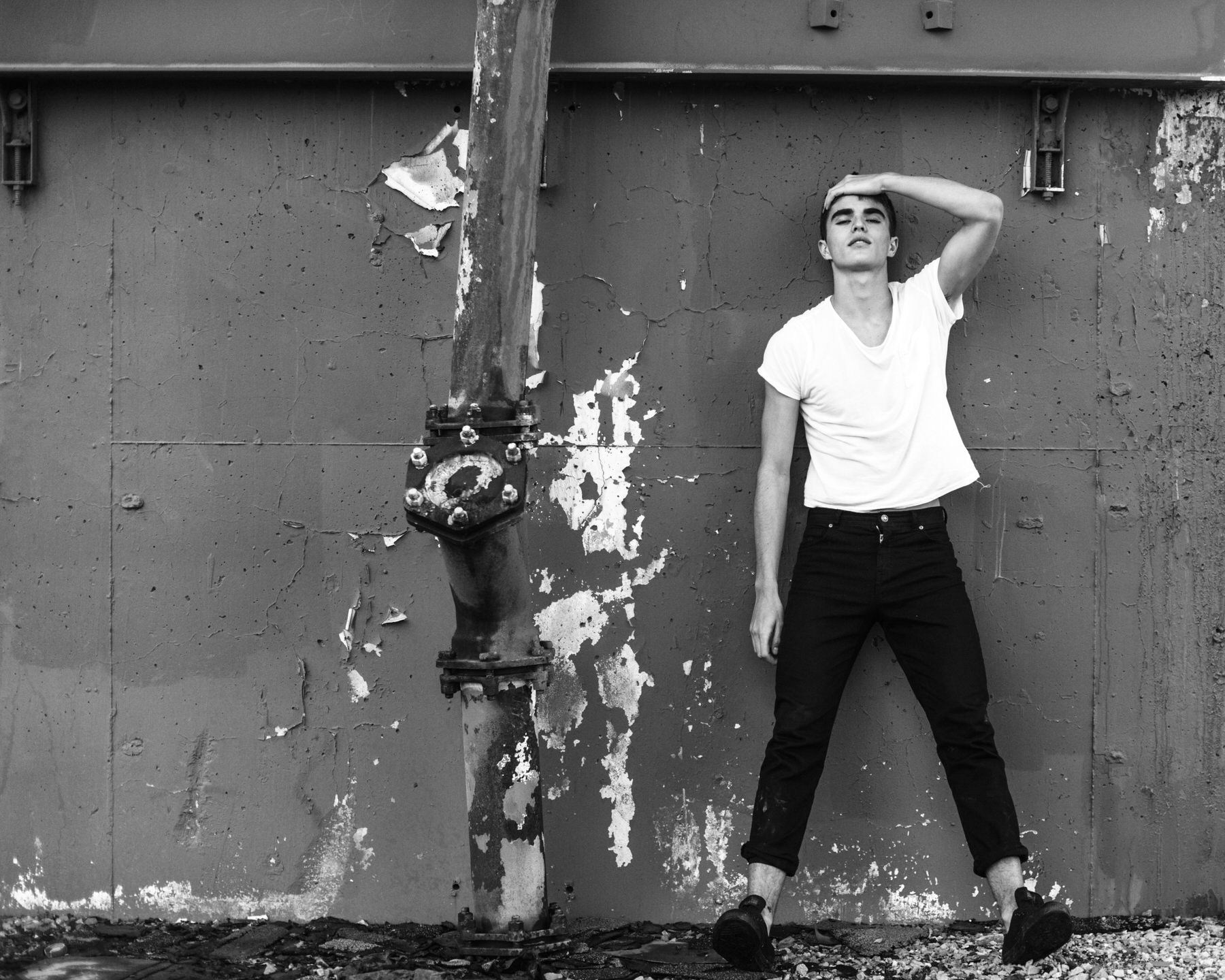 Black and white portrait by photographer Grant Legan of a woman posing dramatically against a wall