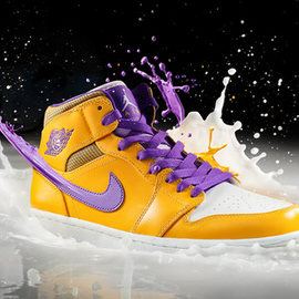 A yellow and purple high-top sneaker splashing through milk against a black background, behind-the-scenes photo from a 'Juicy Kicks' product shoot