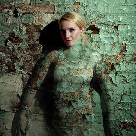Woman body-painted to blend into a cracked stone wall, demonstrating how to create a camouflage effect in Photoshop