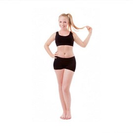 Woman in black activewear standing against a white background, demonstrating how to transform the body in Photoshop