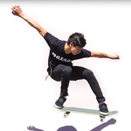 Skateboarder captured mid-trick against a white background, demonstrating how to freeze motion in natural light