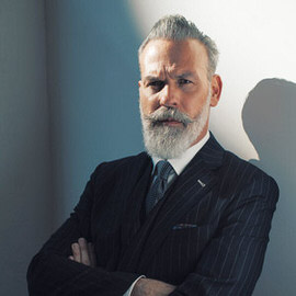 Portrait of a bearded man in a suit with a dark cast shadow on the wall behind him, Photoshop dark shadow fixing tutorial thumbnail