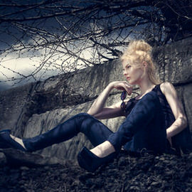 Woman with platinum blonde hair in dark clothing sitting among bare tree branches in a moody dark forest scene, Photoshop dark and dramatic style tutorial thumbnail