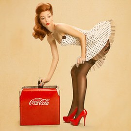 Illustrated retro pinup style woman in a polka dot dress and red heels bending over a vintage cooler, example for creating a pinup style in Photoshop