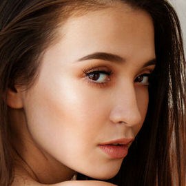 Close-up of a woman's face with filled-in, defined eyebrows, example for filling in eyebrows in Photoshop