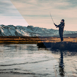 Person fly fishing in a river at sunset with snow-capped mountains behind, example for creating a cinematic realistic color film effect in Photoshop