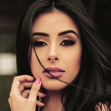 Close-up beauty portrait of a woman with dark hair, bold makeup, and even skin tone, example for color correcting skin in Photoshop