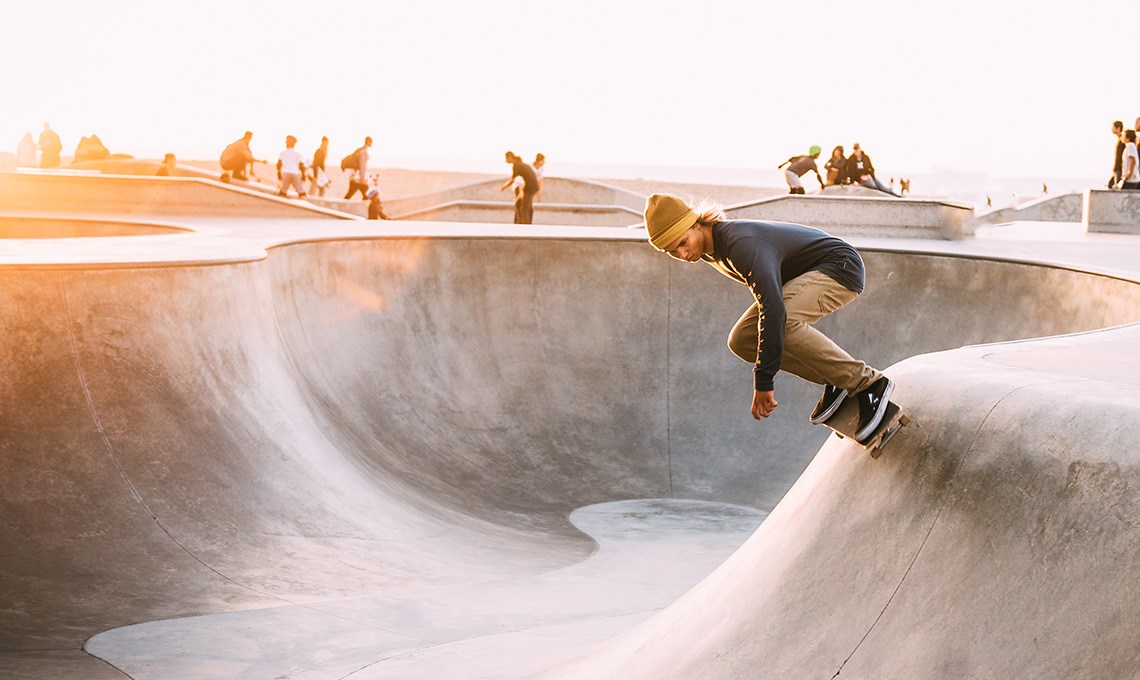 Skateboarder riding up the wall of a concrete skate bowl, before the Sun Flare action is applied