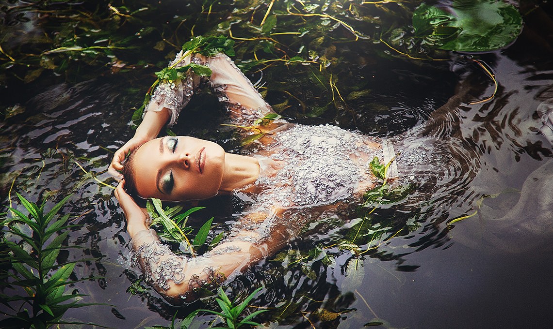 Woman with flowers in her hair floating in water, after the Smart Vignette action is applied