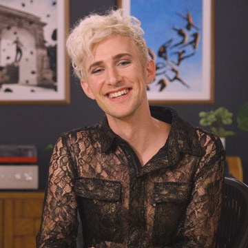 Portrait of photographer and artist Rob Woodcox smiling in a black lace shirt for his PHLEARN interview