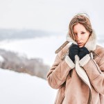 Woman in a shearling coat in a snowy landscape, edited with the Winter presets