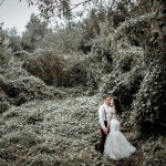 Bride and groom on an overgrown wooded path, edited with the Dark & Moody presets