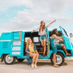 Three friends with a turquoise camper van by the water, edited with the Travel presets