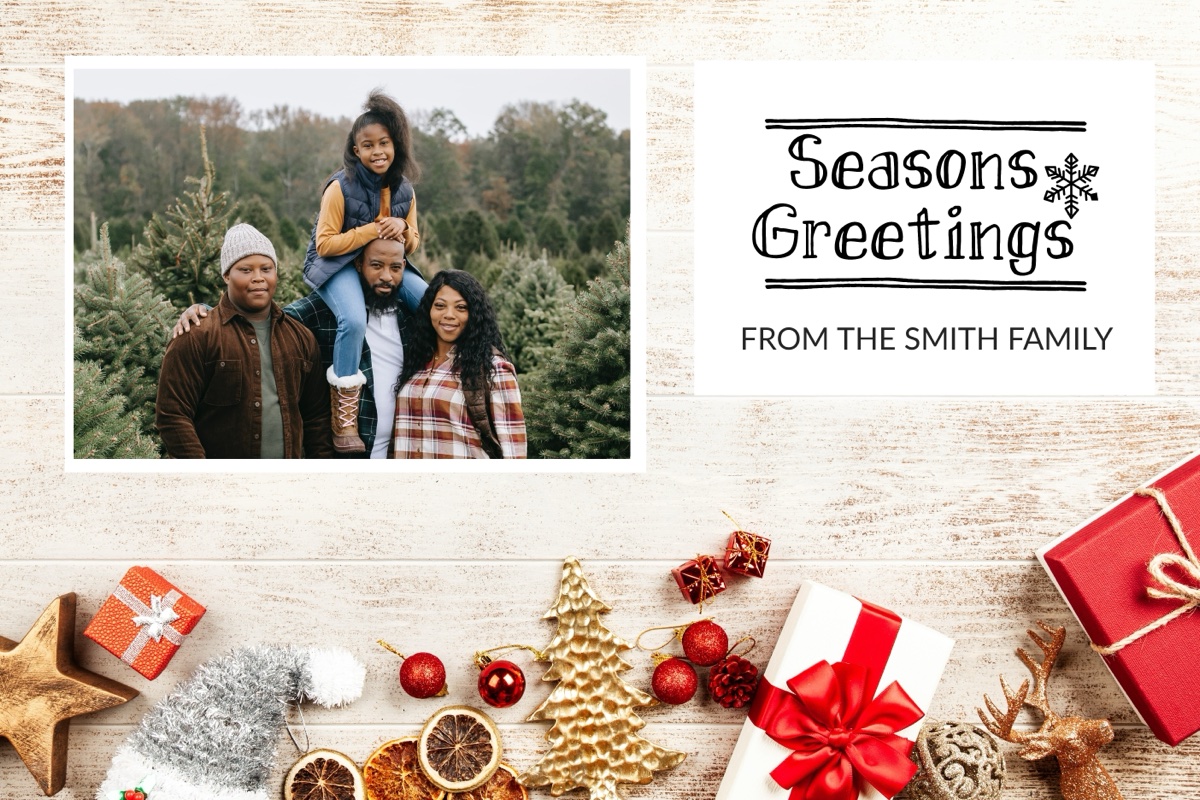 The tree-farm family photo composited into a Seasons Greetings holiday card with gift and ornament graphics on white wood