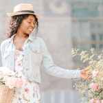 Smiling woman in a straw hat touching pink roses, edited with the Spring presets