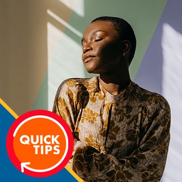 Woman in a floral-patterned jacket with light streaming across a colorful background wall, demonstrating how to change the background color in Photoshop