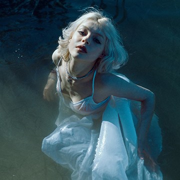 Moody underwater-style portrait of a blonde woman with a textured, painterly finish, demonstrating how to make a texture brush in Photoshop