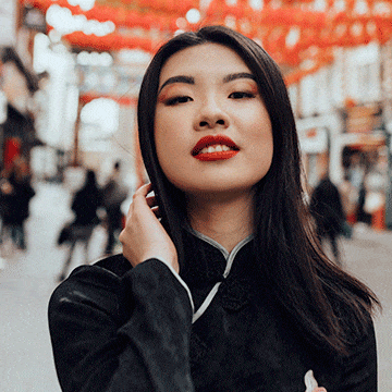 Woman in traditional black attire under red lanterns on a city street, demonstrating advanced object removal by painting in Photoshop