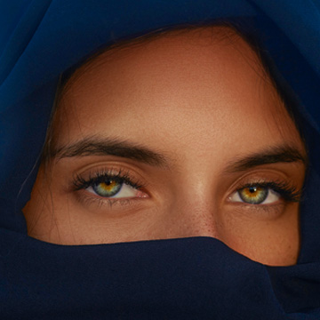 Extreme close-up of a woman's forehead and eyebrows against blue fabric, thumbnail for a tutorial on using AI masking in Photoshop