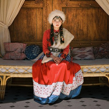 Woman in traditional Mongolian-style headdress and clothing seated indoors, thumbnail for a tutorial on using Adobe Camera Raw in Photoshop