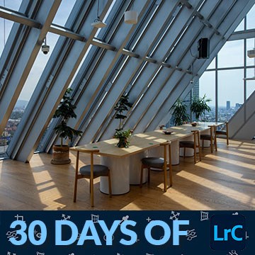 Modern glass-ceilinged dining room with a city skyline view, thumbnail for a tutorial on merging bracketed exposures into HDR in Lightroom