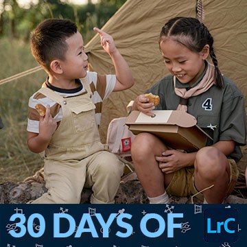 Two children in scout-style camp costumes sharing a pastry, thumbnail for a tutorial on flags, stars and smart collections in Lightroom
