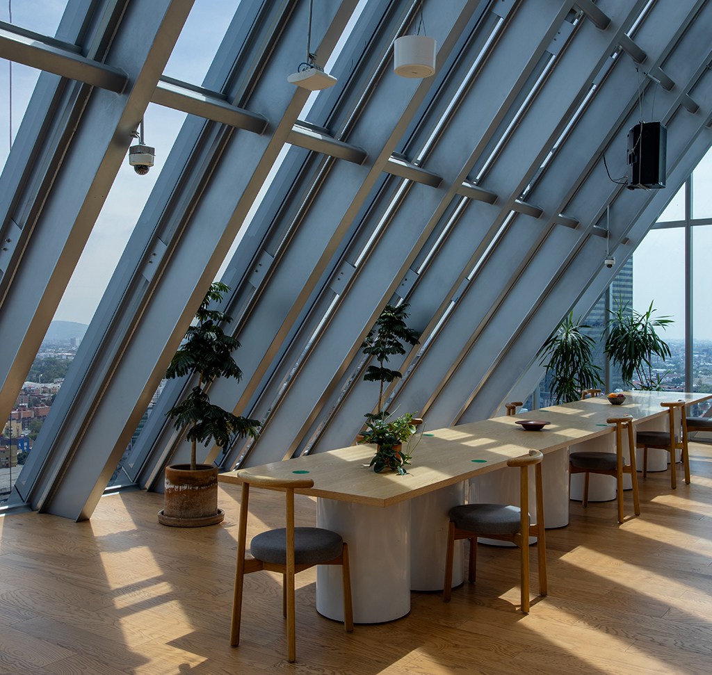 A sunlit office interior with angled glass roof beams and a city view, merged from bracketed exposures into one HDR image in Lightroom Classic