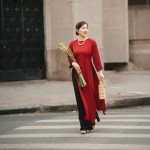 A woman in a red dress crossing a street
