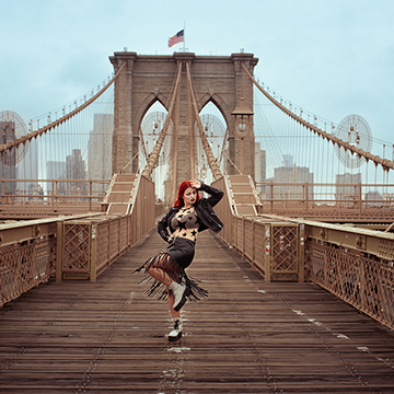 Woman with red hair posing on the Brooklyn Bridge walkway, thumbnail for an advanced color grading tutorial in Lightroom and Adobe Camera Raw