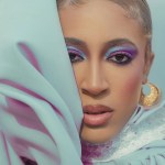 A woman in pale blue with bright makeup