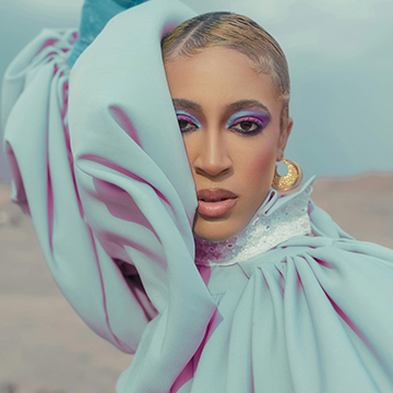 Portrait of a woman with light blue and pink draped fabric and purple eyeshadow, thumbnail for a tutorial on color coordinating elements in Photoshop