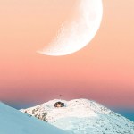 A crescent moon over a snowy mountain