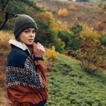 A woman in a beanie on a hillside with a rabbit