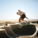 A skateboarder in the air above a skate bowl