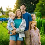 A family of five in a green garden