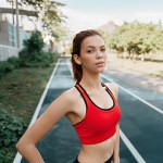 A woman in a red sports bra on a running track