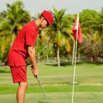 A golfer in red on a green