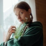 A woman holding a plant in front of her face