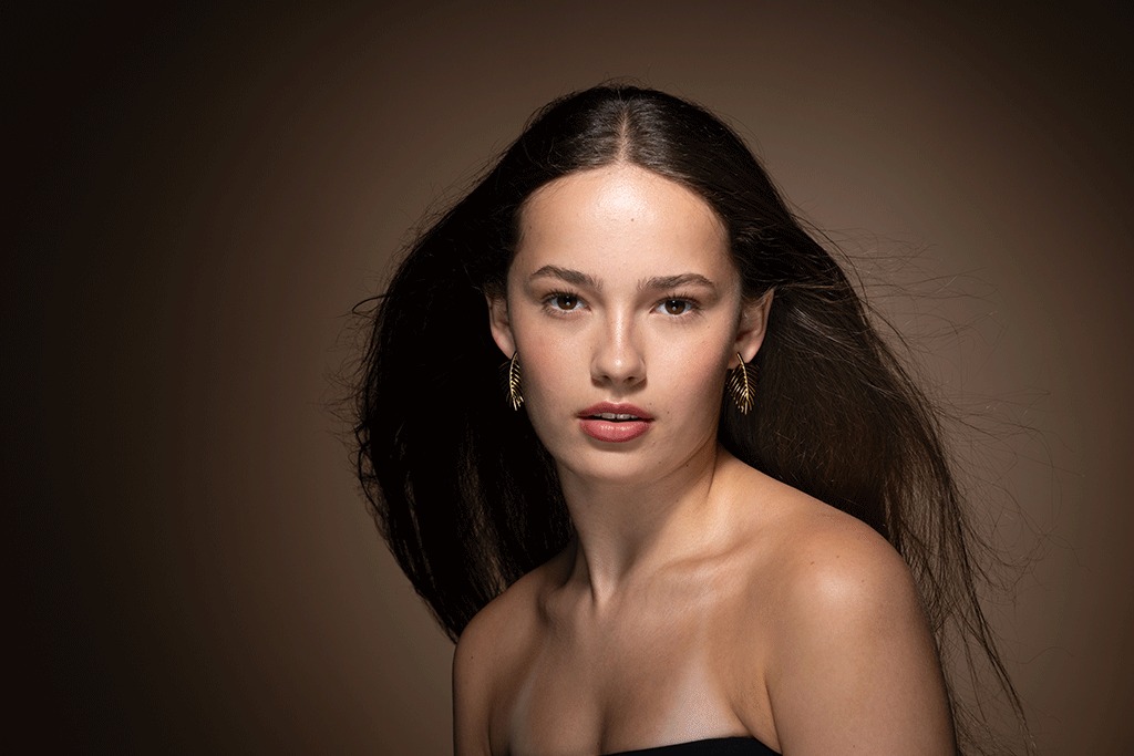 Portrait of a woman against a warm brown background