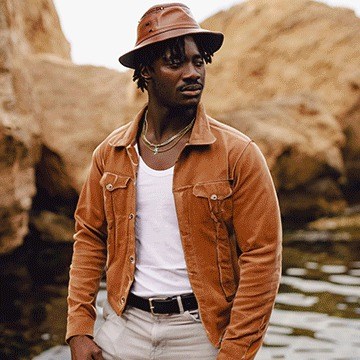 Man in an orange jacket on a beach, edited with AI tools in Photoshop