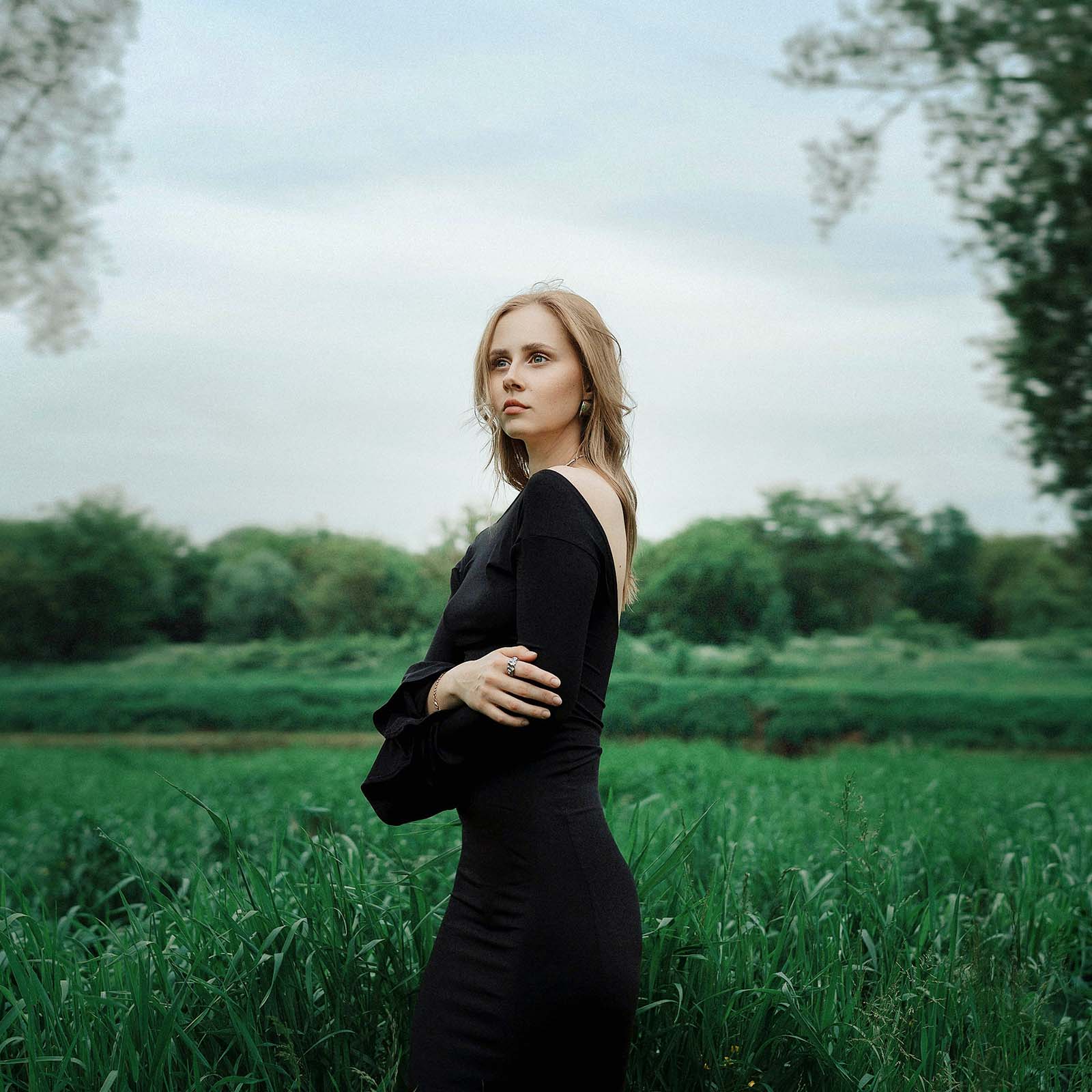 The same field portrait after masked Light adjustment layers in Photoshop, with the subject brightened, the background opened up and a soft glow added behind her