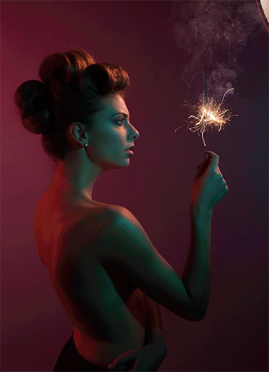 Profile portrait of a woman lit with teal and red studio light