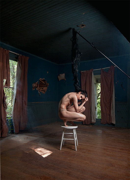 Dark teal room with a wooden chair and an empty swing