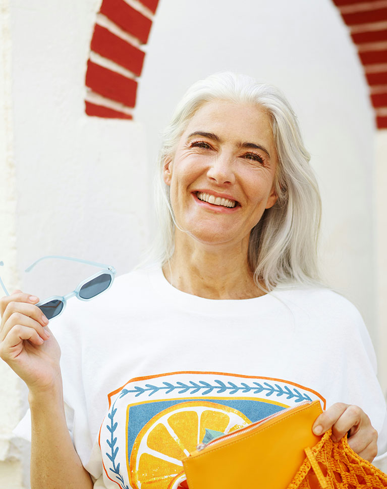 A woman with white hair against a white wall