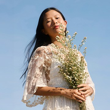 The Ultimate Guide to Selections and Masking in Photoshop course thumbnail: a woman holding wildflowers against a blue sky