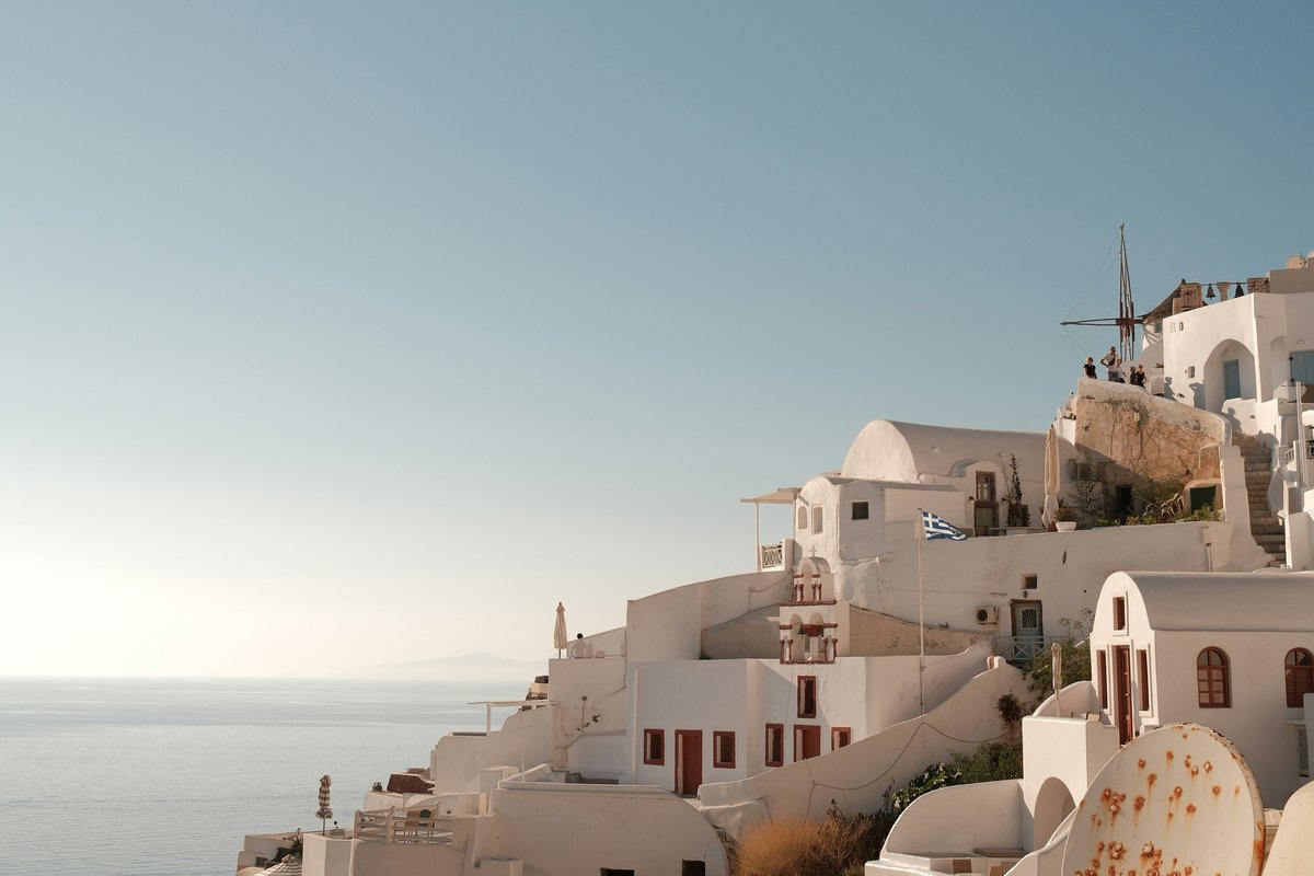 White Santorini buildings under a plain blue sky before the sky composite