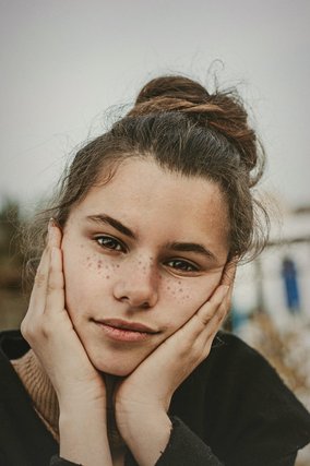 Freckled woman with her hair in a bun
